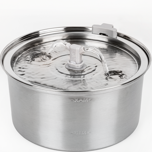 a water fountain with a white spout with text: '- XAM-'